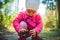 Adorable baby on forest path in nature. Portrait of 1 year old girl in woods with pine cone