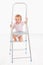 Adorable baby girl climbing on ladder smiling