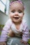 Adorable baby girl crawls on all fours floor at