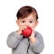 Adorable baby girl eating a red apple