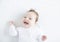 Adorable baby girl laughing toothless on a white b