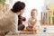 Adorable baby girl playing with educational toys in nursery. Child having fun with colorful different toys at home