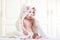 Adorable baby girl sitting under a hooded towel after bath