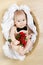 Adorable baby holding flowers, butterfly tie