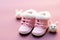 Adorable baby pink booties for tiny feet, resting on a hares cap