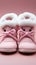 Adorable baby pink booties for tiny feet, resting on a hares cap