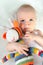 Adorable baby playing with colorful hand made crochet toy