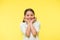 Adorable baby smiling. Full of excitement. Girl happy smiling face touches her cheeks yellow background. Pupil excited