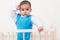 Adorable baby toddler posing in the bed with hand on head on white background