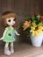 Adorable BJD ball joint doll standing next to the faked flowers pot