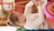 Adorable blonde girl preschool student sitting on table drawing on paper at kindergarten