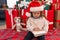 Adorable blonde toddler writing santa claus letter sitting on floor by christmas gifts at home