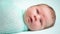 Adorable blue-eyed newborn baby lying and looking