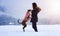 Adorable Boxer Dog playing with her owner in snow