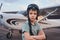 Adorable boy in aviation hat standing at aerodrome