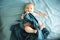 Adorable boy in the bedroom. A newborn baby is resting in a blue-colored bed.