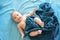 Adorable boy in the bedroom. A newborn baby is resting in a blue-colored bed.