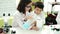 Adorable boy and girl student pouring liquid on test tube at laboratory classroom