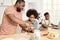 Adorable boy helping his father with kneading homemade dough