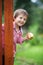 Adorable boy, holding apple, standing next to a door