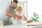 adorable boy whisking dough while his father pouring milk into bowl