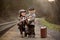 Adorable boys on a railway station, waiting for the train with suitcase and beautiful vintage doll