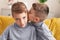 Adorable boys sitting on sofa kissing at home