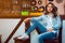 Adorable brunette in casual jeans look behind bar table