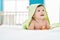Adorable caucasian baby wearing funny towel lying on bed at bedroom