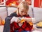 Adorable caucasian boy wearing vampire costume cutting paper at home