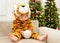 Adorable caucasian child with costume of tiger,symbol of New 2022 Year sitting on sofa near Christmas tree,play with