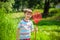 Adorable Caucasian kid playing with scoop-net on the meadow on warm and sunny summer or spring day.