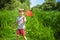 Adorable Caucasian kid playing with scoop-net on the meadow on warm and sunny summer or spring day.