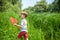 Adorable Caucasian kid playing with scoop-net on the meadow on warm and sunny summer or spring day.