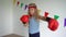 Adorable child with boxing gloves. Cute girl train for self-defense. slow motion