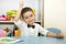 Adorable child boy draws a brush and paints in nursery room. Kid in kindergarten in Montessori preschool class.