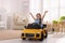 Adorable child driving toy car in room at home