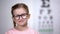 Adorable child in eyeglasses smiling into camera vision correction for children