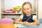 Adorable child girl draws a brush and paints in nursery room. Kid in kindergarten in Montessori preschool class.