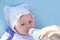 Adorable child girl with infant formula in bottle drinking milk