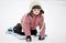 Adorable child girl sledding in snow on a saucer