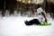 Adorable child girl sledding in snow on a saucer