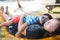 Adorable child hugs mother lying on beach hammock and acts like a baby