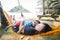 Adorable child hugs mother lying on beach hammock and acts like a baby