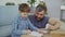 Adorable child junior school student is doing homework writing in exercise book with his father. Education, children