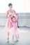 adorable child in pink tutu looking at camera while training with teacher