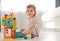 adorable child playing with multicolored building blocks on floor