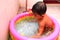 Adorable child playing with water in a small inflatable pool