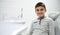 Adorable child preadolescent boy sitting in dentist`s chair during dental appointment for regular medical preventive check-up,