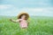 Adorable child singing in a straw hat with a bouquet of yellow flowers in the middle of a beautiful field of flowers